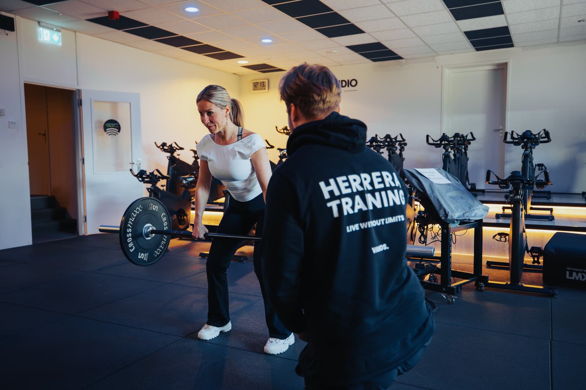 Coach begeleidt een klant tijdens krachttraining bij Herrera Training